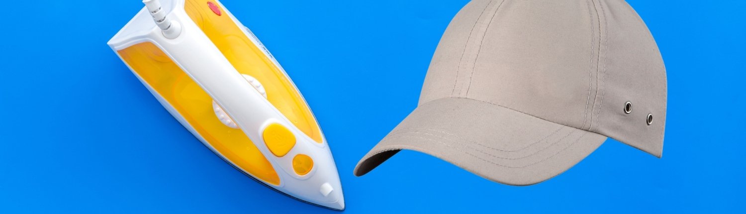 an electric yellow iron and blank hat together indicating how to do iron on yourself
